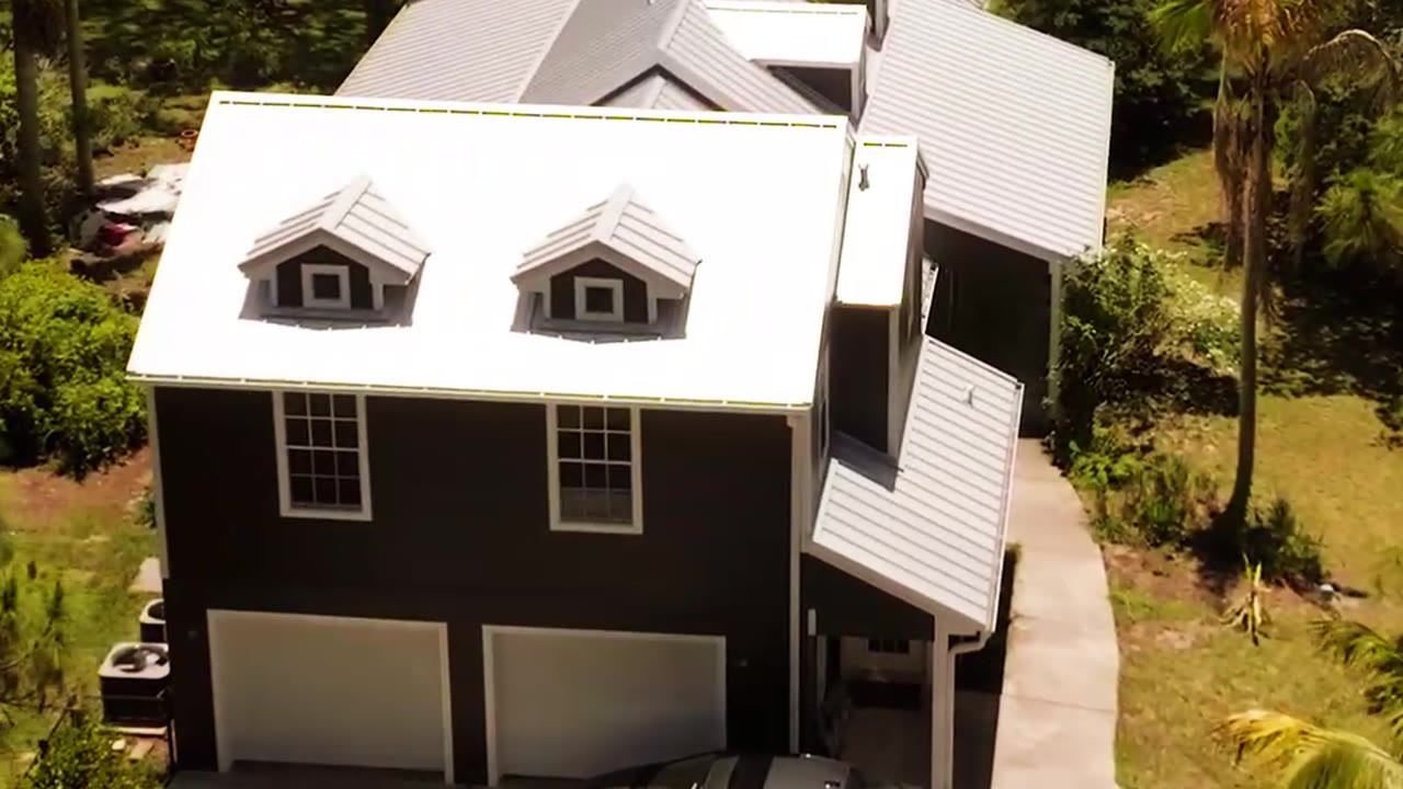 Aerial view of a two-story home with a white standing seam metal roof FoxHaven installed
