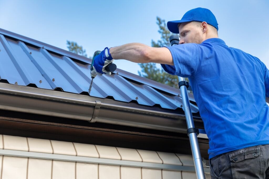 Roofer installing metal roofing solution on residential home