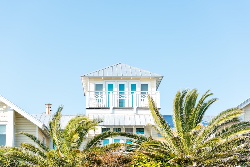 Beach house with metal roof above the palm tree tops