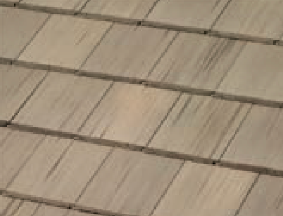 Close-up view of beige rectangular roof shingles arranged in overlapping rows, with a wood-like texture and visible lines between each shingle.