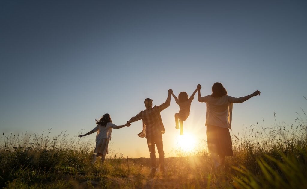 Happy family in the park. Father, mother and children are running, having fun and enjoying summer evening.