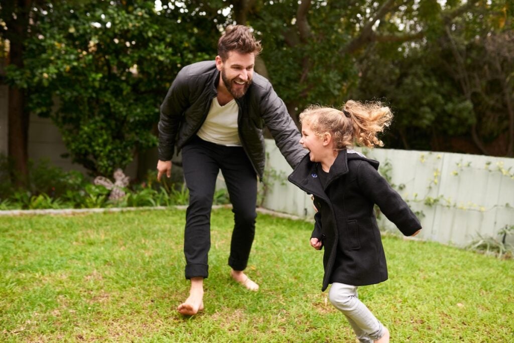 Shot of a father and daughter playing together outside.