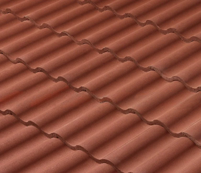 Close-up view of overlapping red-brown clay roof tiles arranged in wavy, parallel rows, creating a textured, repeating pattern.