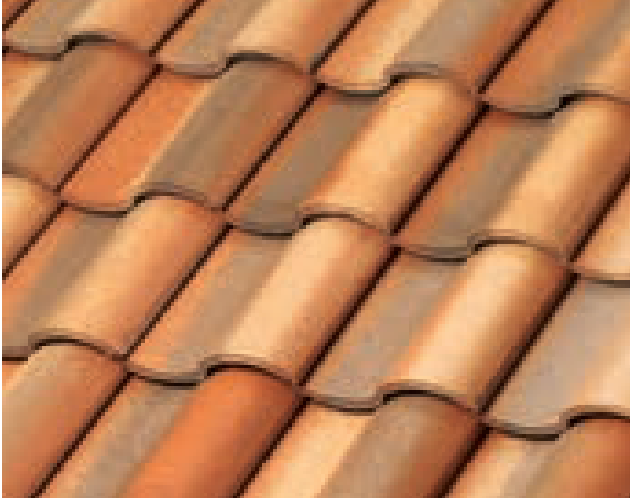 A close-up view of overlapping terracotta roof tiles arranged in neat, wavy rows, displaying various shades of reddish-brown and orange.