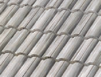 Close-up view of a gray, wavy, corrugated roof with overlapping tiles arranged in horizontal rows. The tiles have a repetitive, ridged texture.