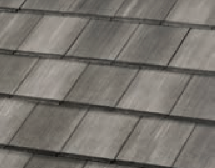 A close-up view of a gray, shingle-style roof with overlapping rectangular tiles arranged in neat rows. The shingles have a slightly weathered appearance.