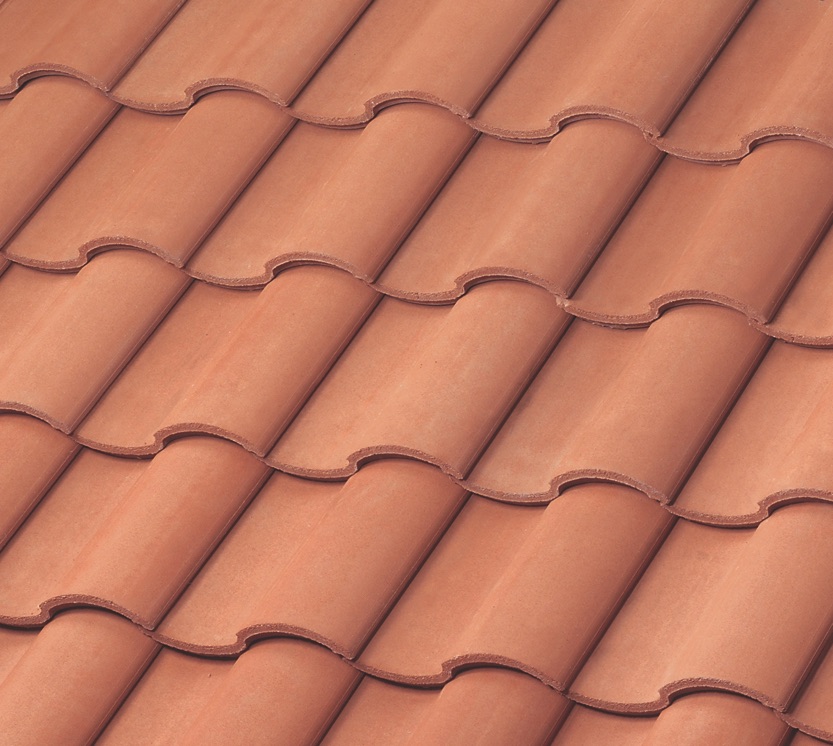 Close-up view of overlapping red clay roof tiles arranged in neat, horizontal rows, showing their curved, wavy pattern and smooth texture.