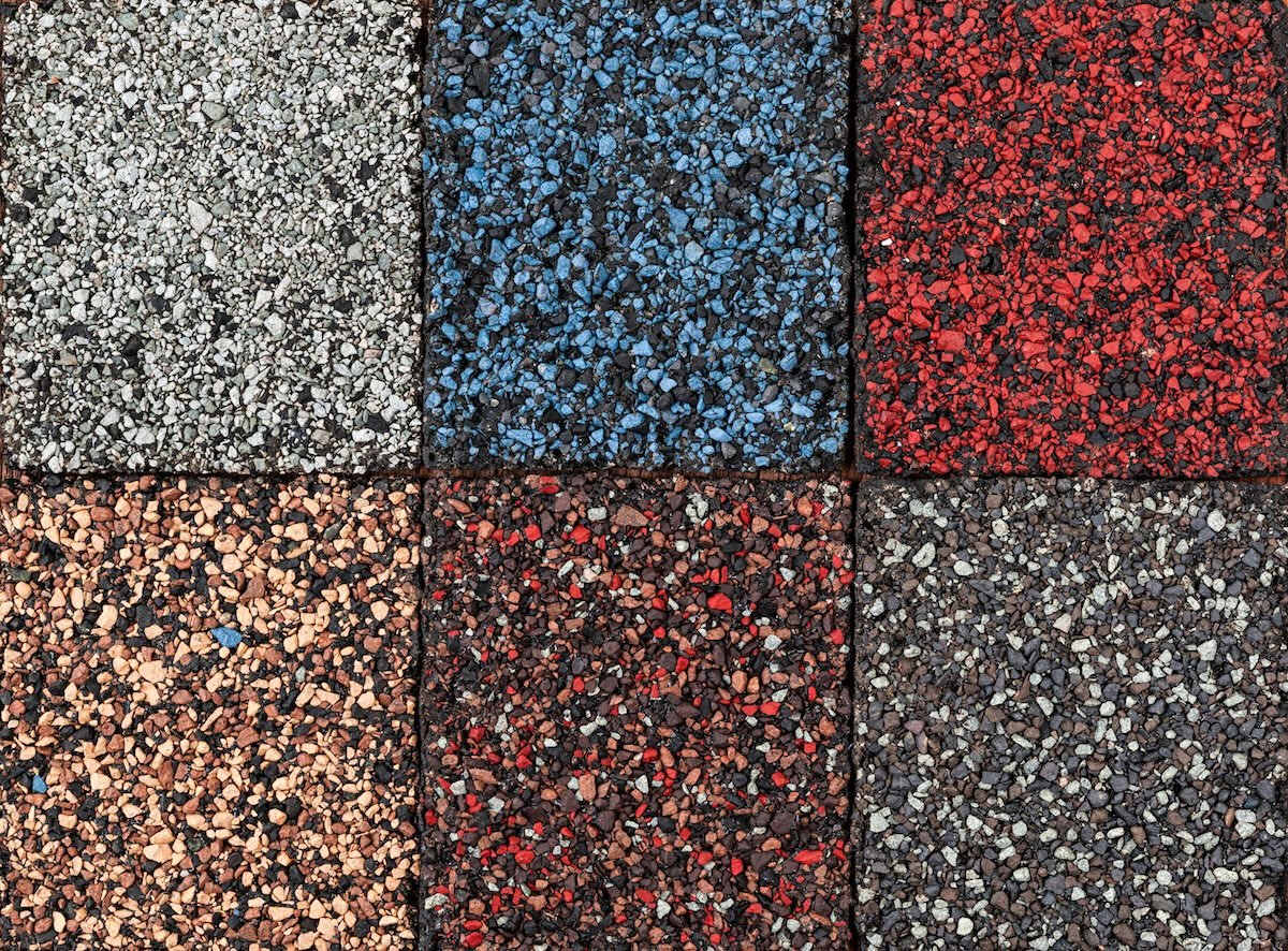A grid of six square tiles, each featuring small gravel or crushed stone in different colors: gray, blue, red, tan, blends of red and black, and gray and black