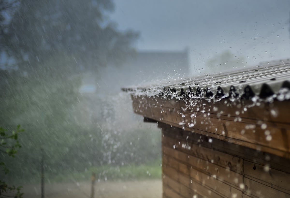 Heavy rain pours down on a wooden roof
