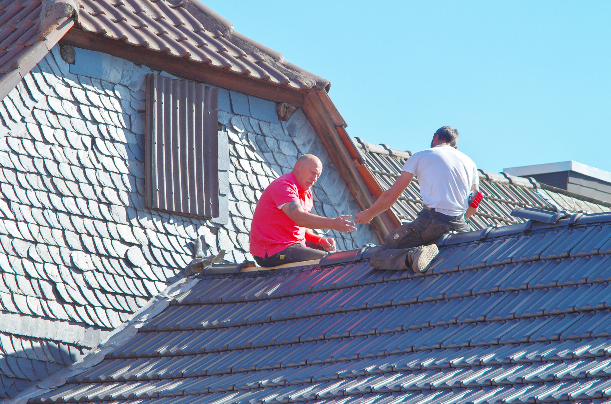 Professional roof inspector examining roof with homeowner, showing inspection process and detecting hidden problems