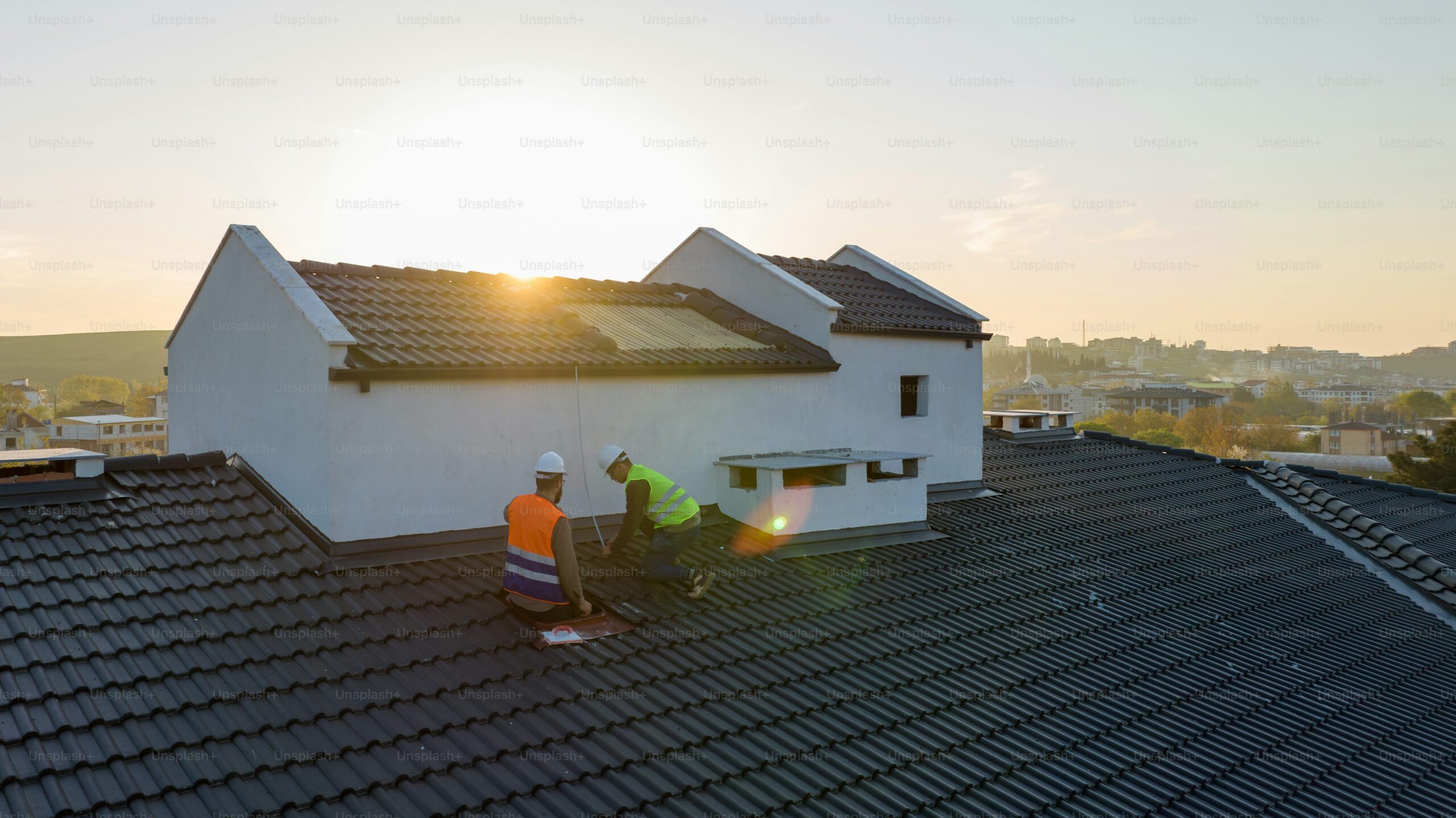 Professional roofers installing GAF shingles on a modern residential home