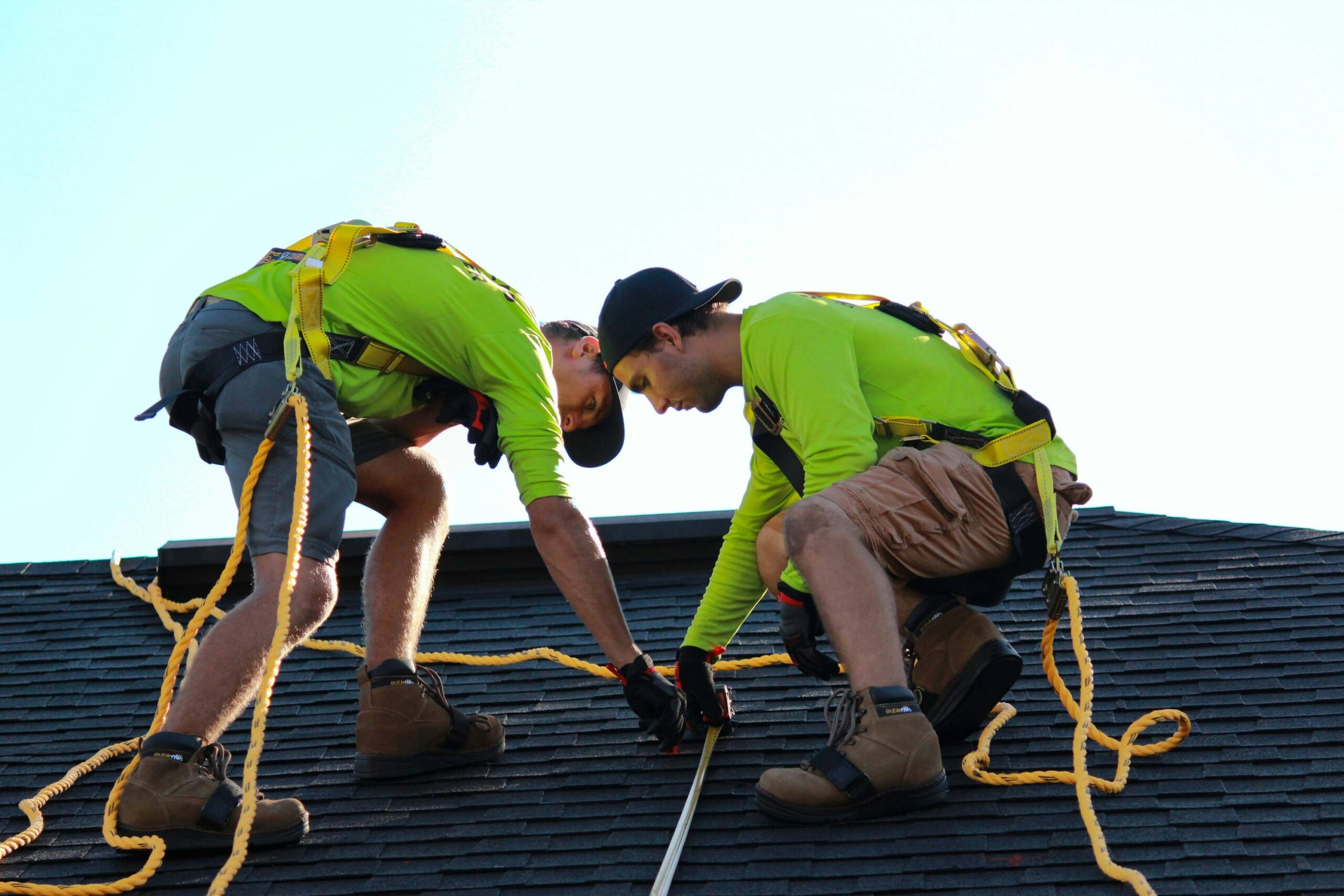 Homeowner and contractor inspecting roof edges for wind damage and discussing reinforcement options