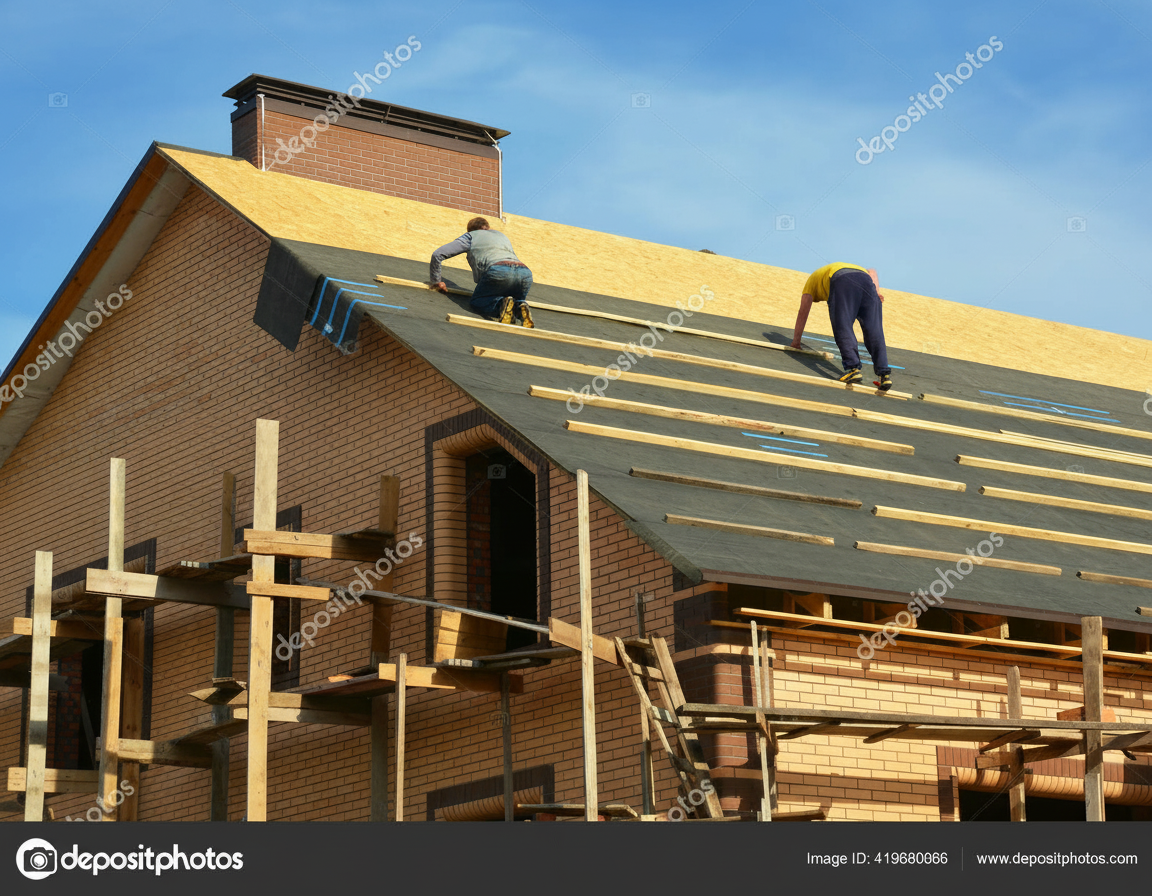 Professional roofing contractors carefully installing waterproof underlayment on a residential roof deck